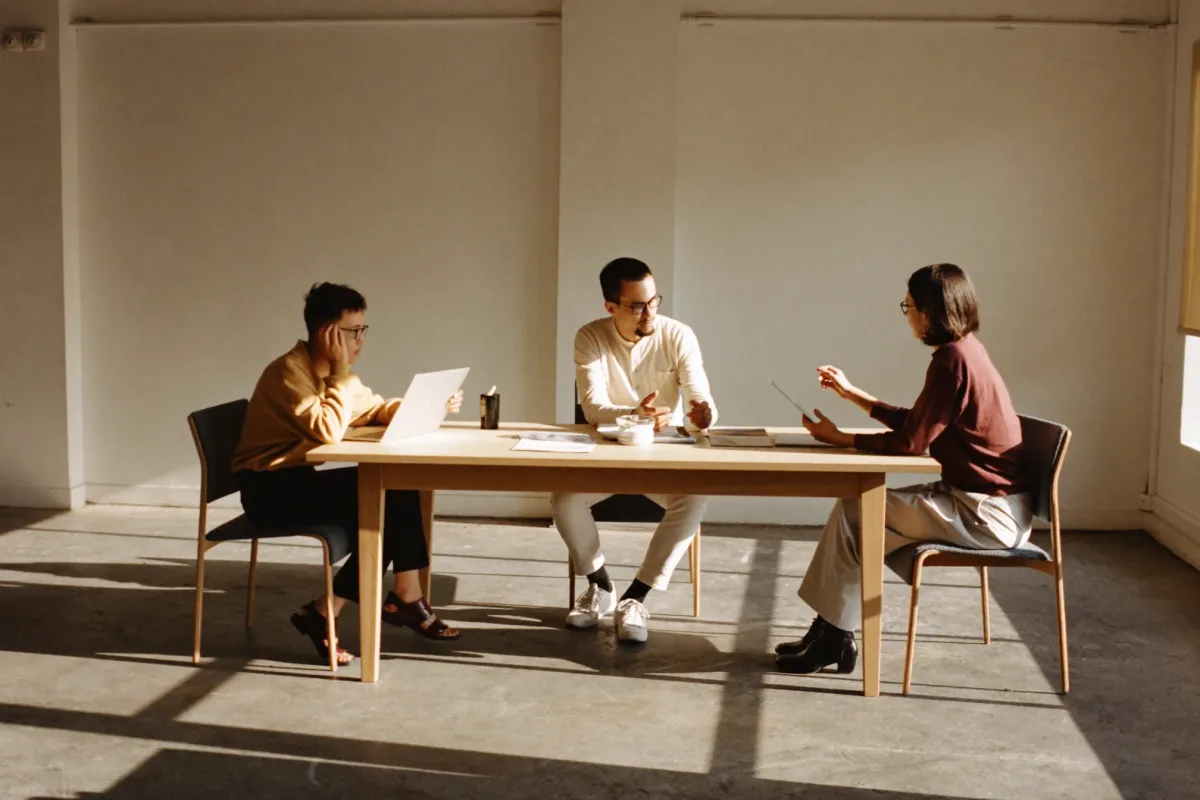 Three colleagues talking around a table